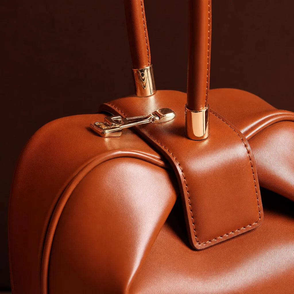 Professional fashion construction macro, 1:1 square. Isolate the exact brown Signature Elegance hand
