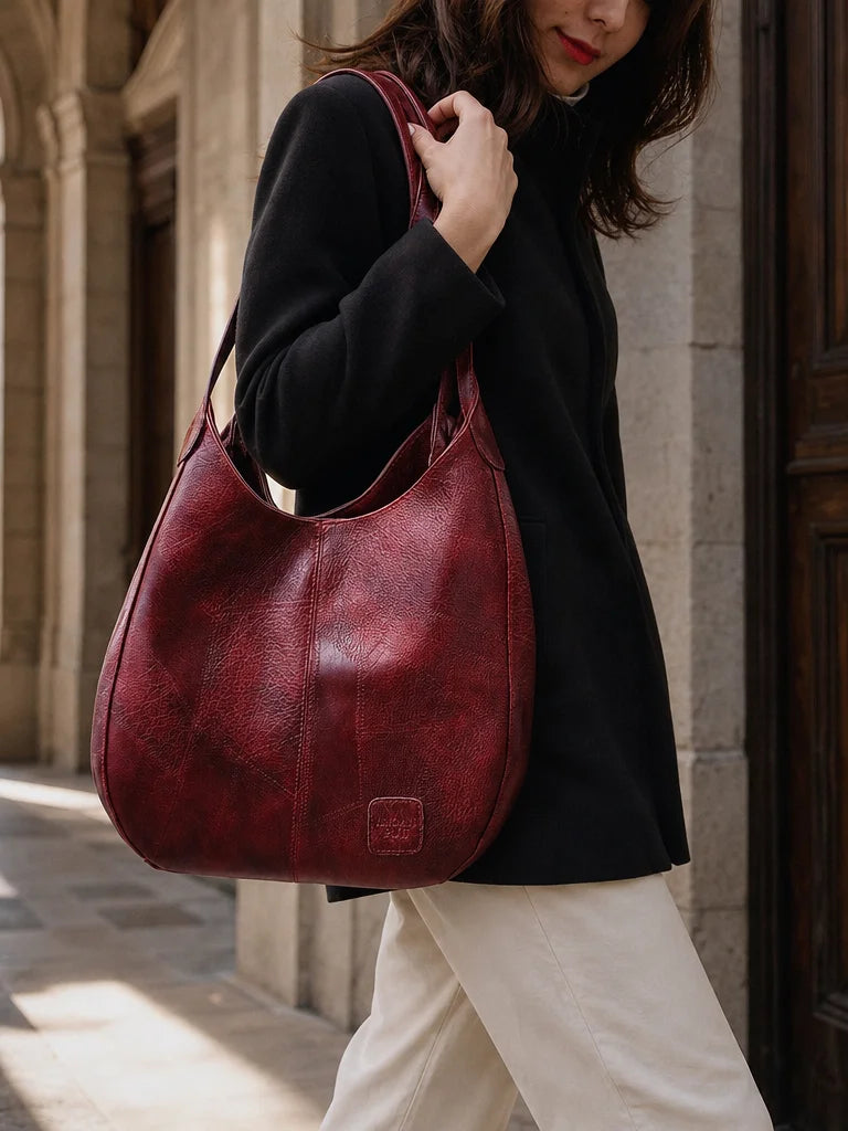 Professional reference-worn fashion photograph, 3:4 portrait. Show the exact red patchwork hobo bag